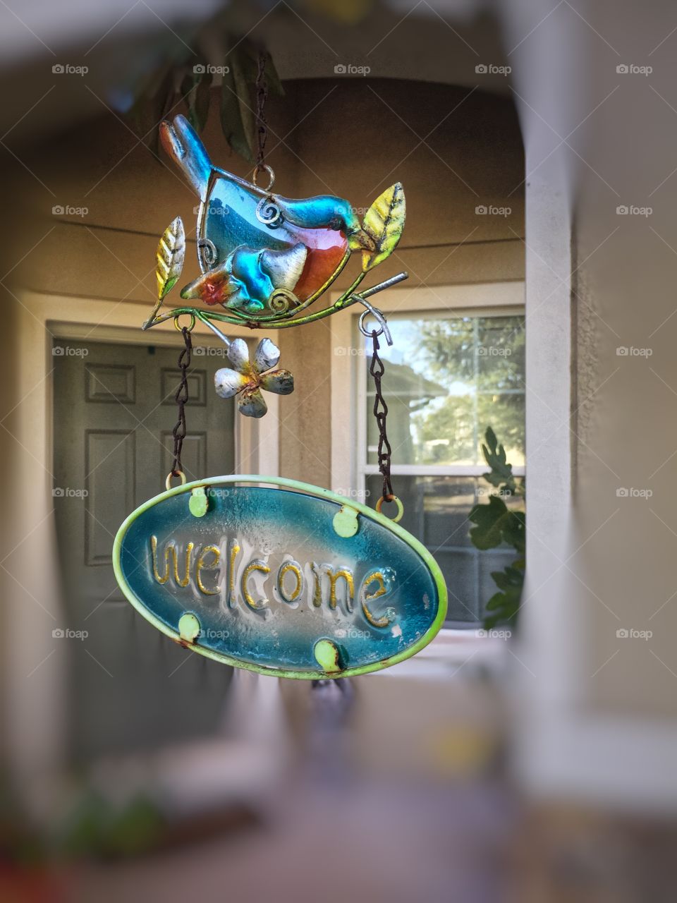 Welcome sign with a bird hangs in front of the door