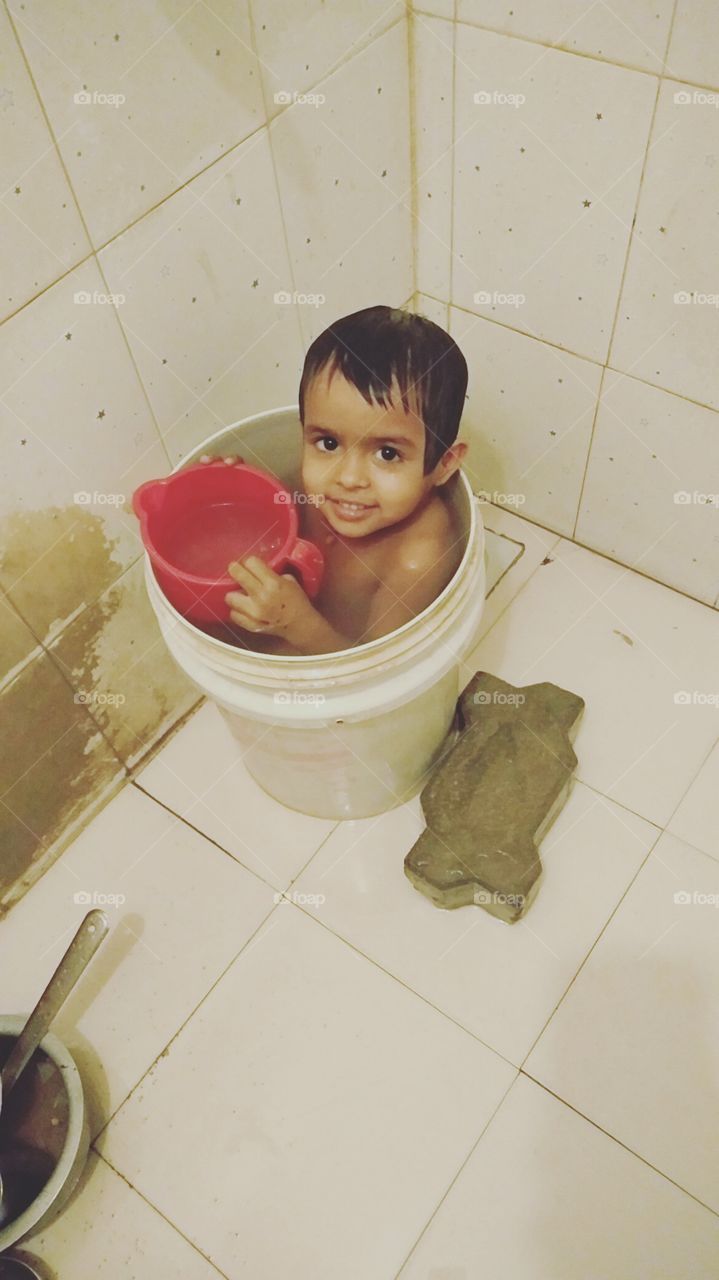 This baby is taking a bucket, So Cute Baby, Beautiful baby, The baby is taking bath in the bathroom, This Girl in the bucket, Enjoy in Summer Time, Nice Baby,