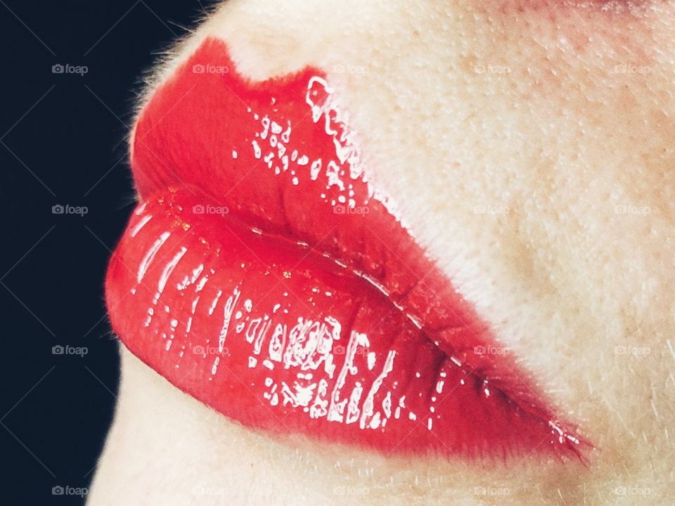 Close up of glossy red lips on young woman