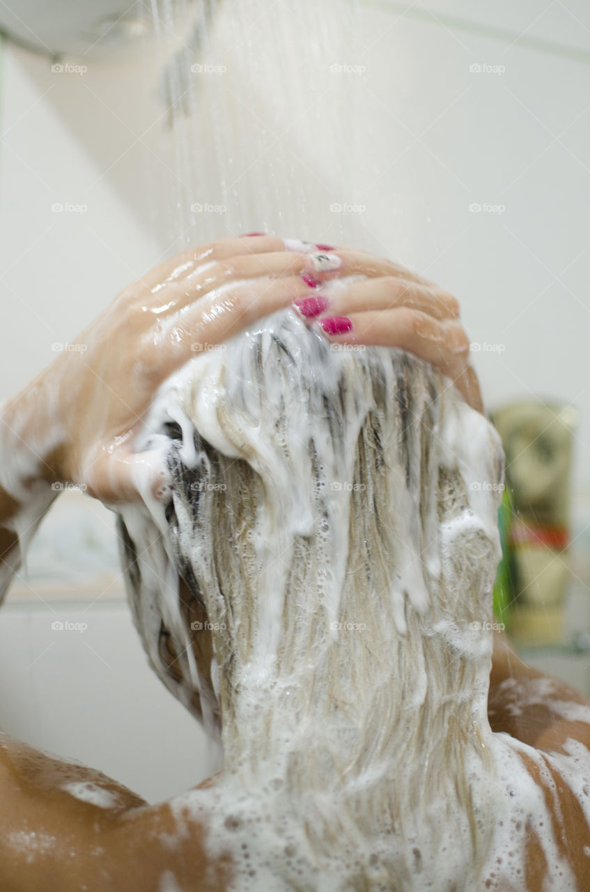 Woman washing shampoo off her hair