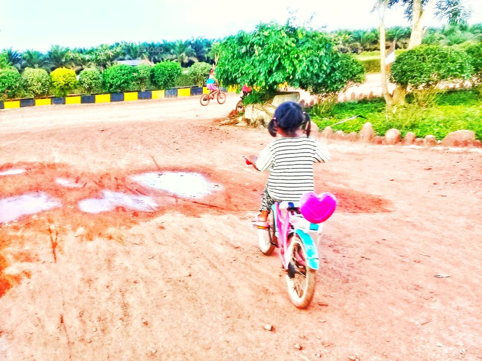 a girls is playing a bicycle in the palm oil plantation office complex in seruyan,central kalimantan Indonesia