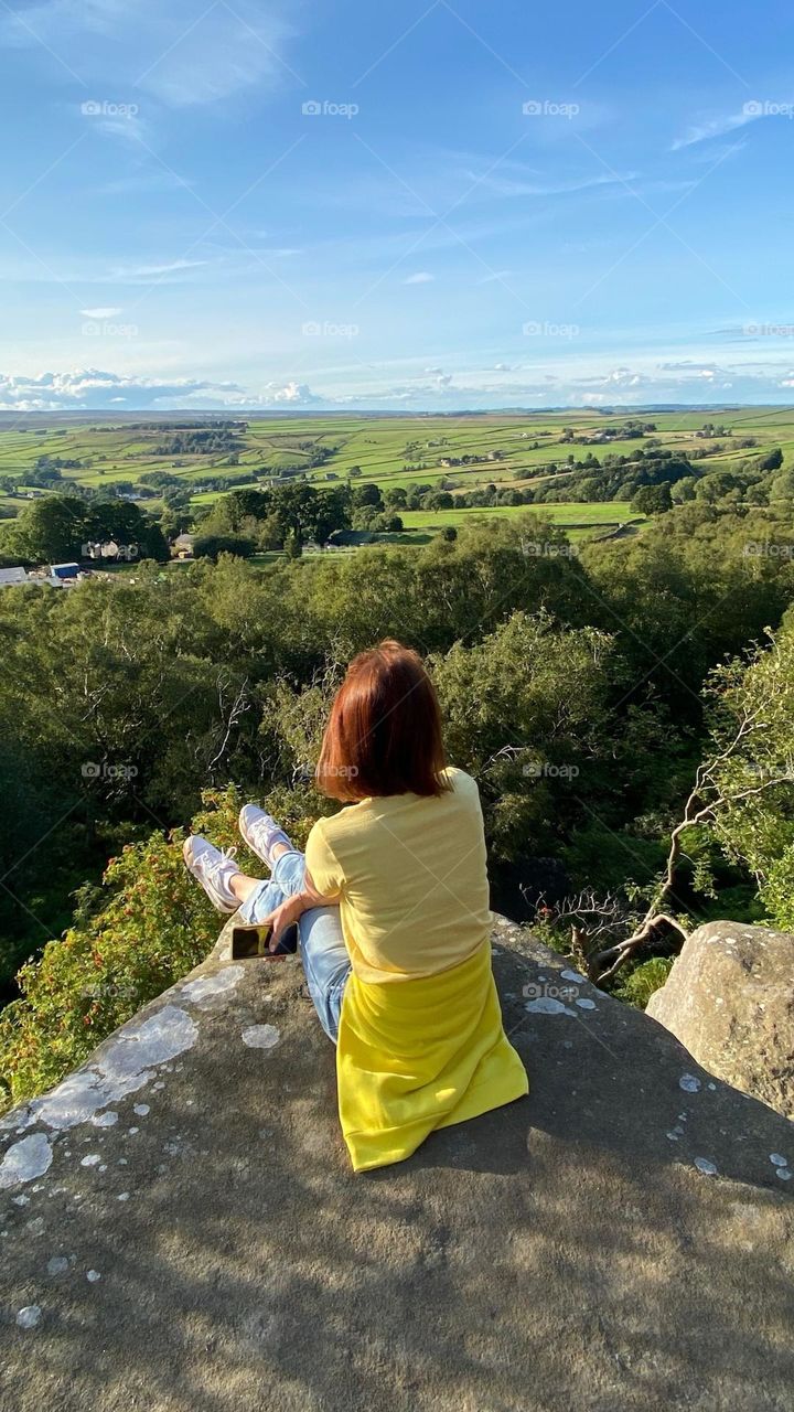 Love yellow color. Beautiful scenery, amazing landscape. Woman in yellow clothing admire the nice view.