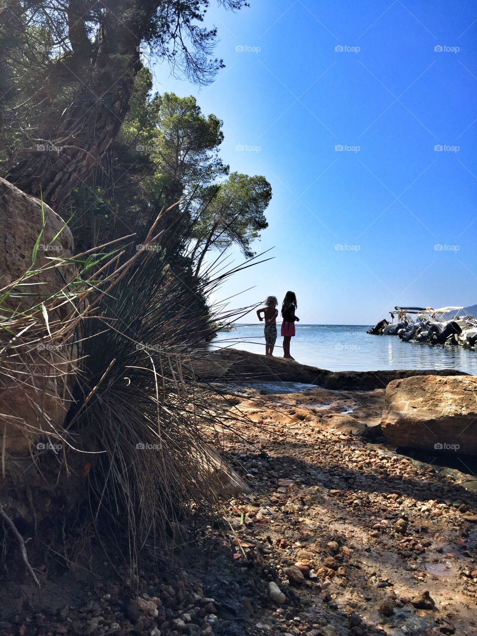Kids standing by the edge of the water