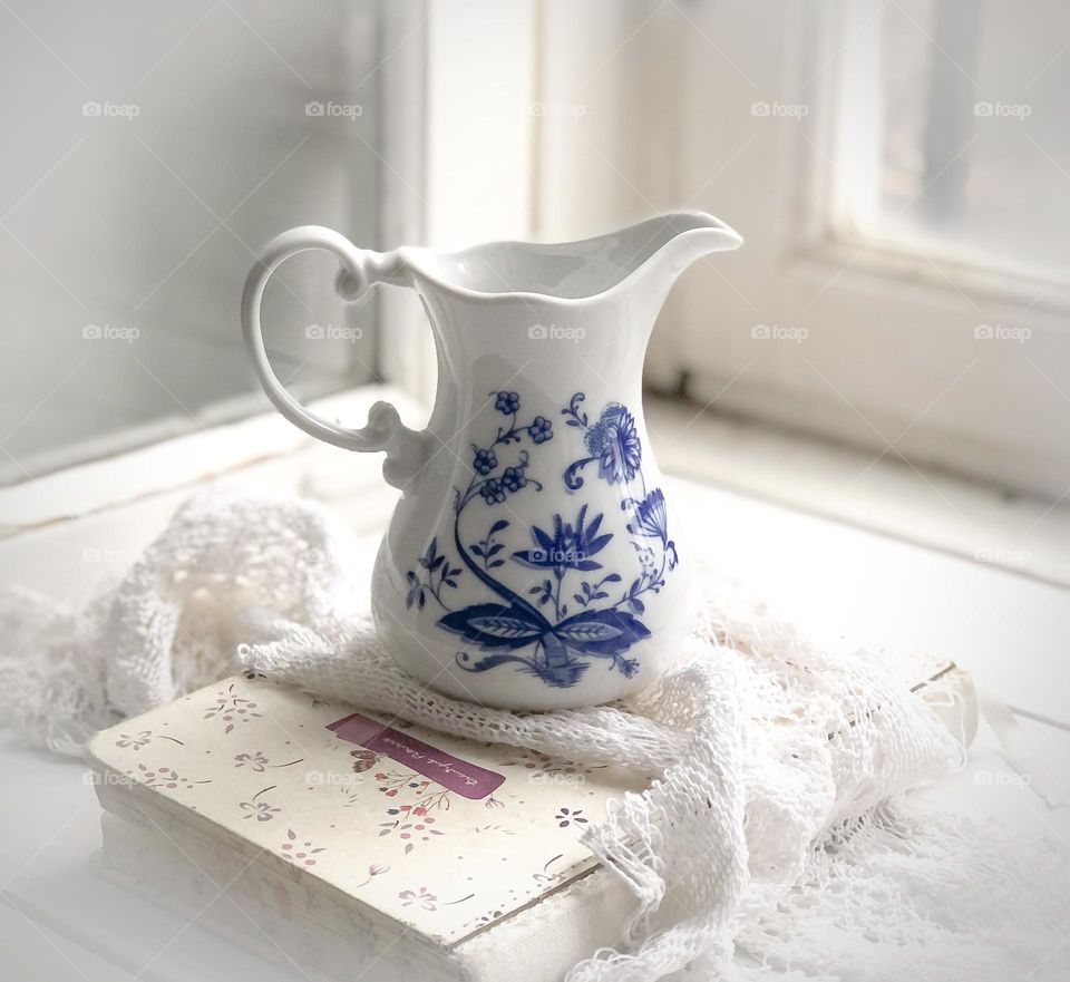 Old porcelain white creamer with blue ornament