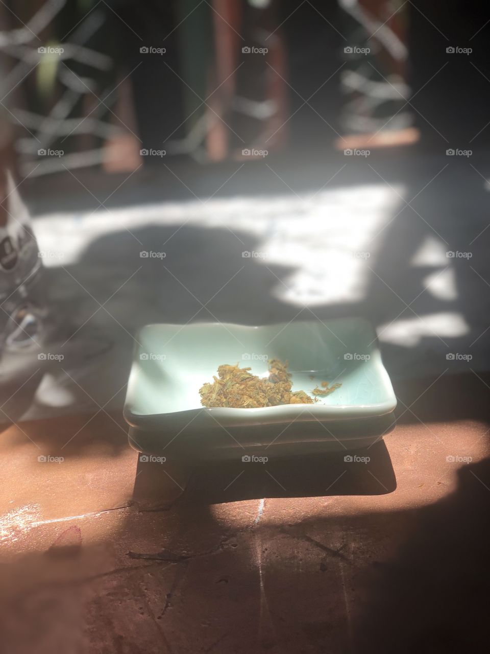 Marijuana in ceramic dish in daylight with shadows