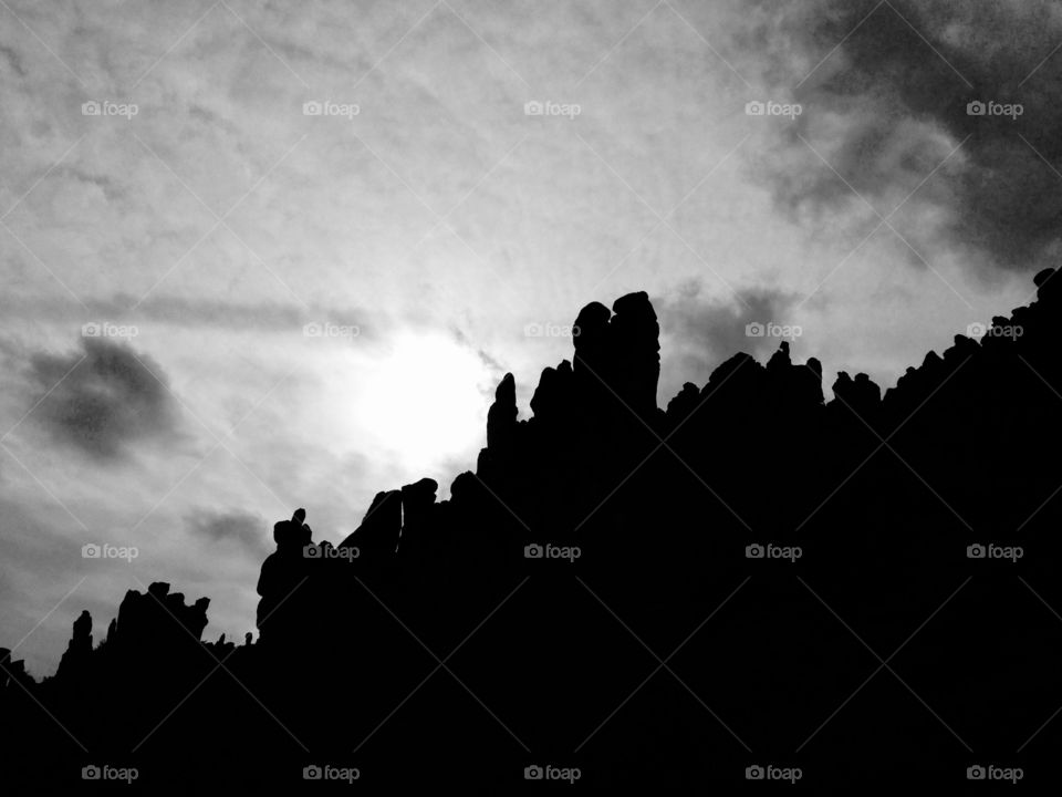 Dark hoodoos silhouetted against a cloudy sky in Queen Valley, Arizona