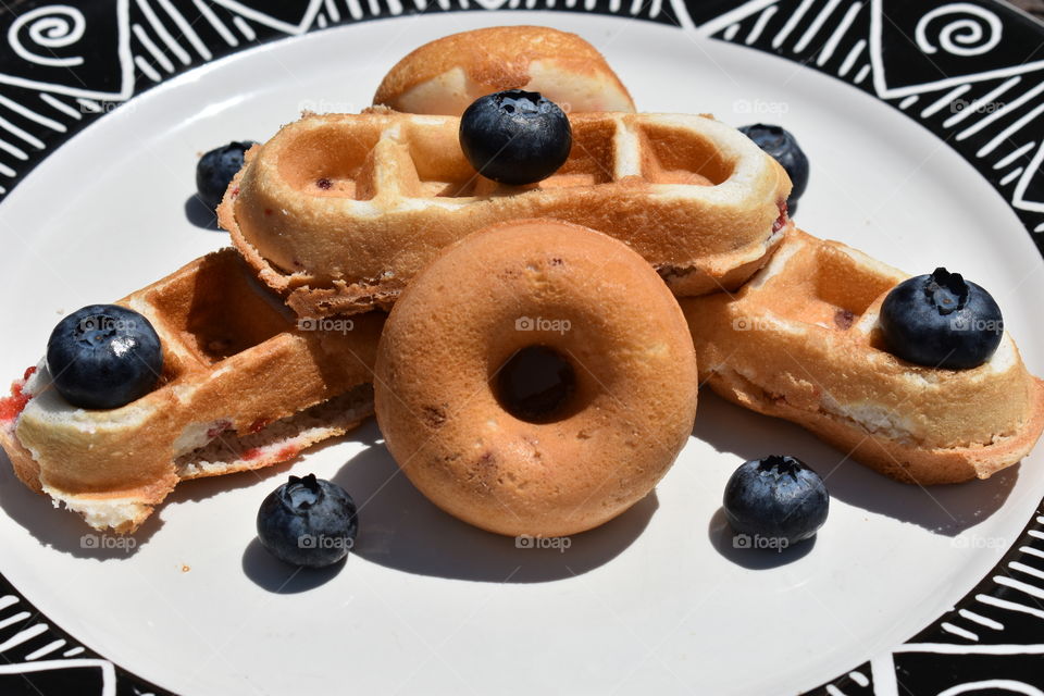 Strawberry waffles and doughnuts with blueberries.
