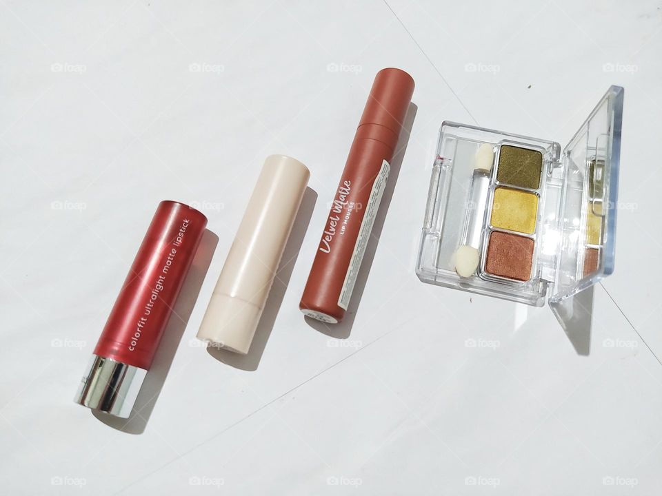 Top view, isolated on white background with some lipstick and eyeshadow kit