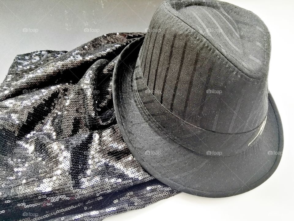 fashionable hat and a simple black evening dress with sparkling sequins