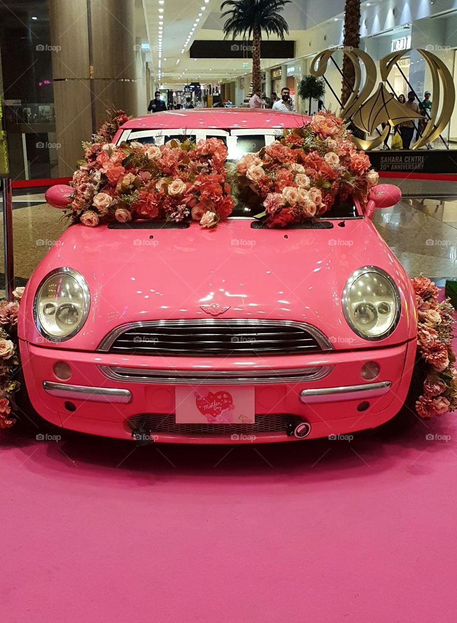 pink car displayed in a shopping mall