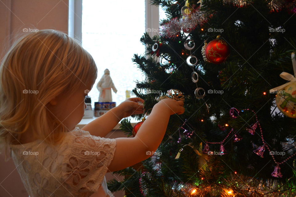 Girl decorates christmas tree