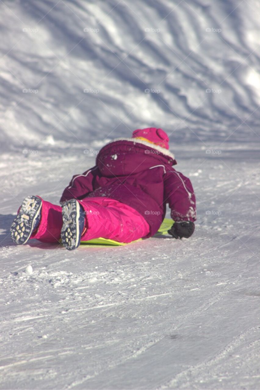 Sled riding down the hill.  