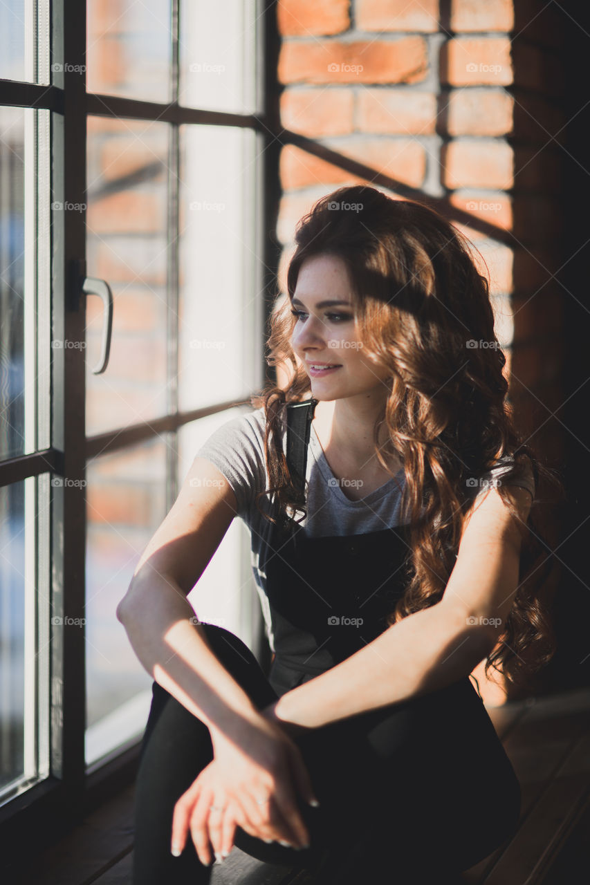 Portrait of young beautiful woman near window