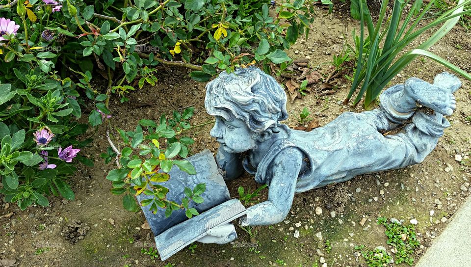 Small statue of child reading in a garden!