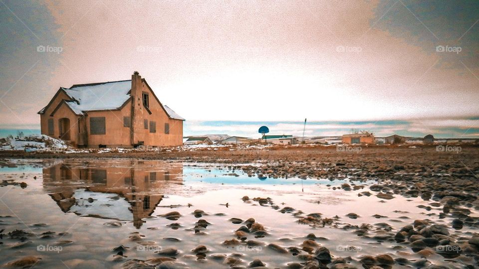 Reflective puddle into snowy plains