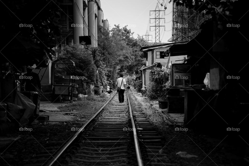 Man walking away down the train track 