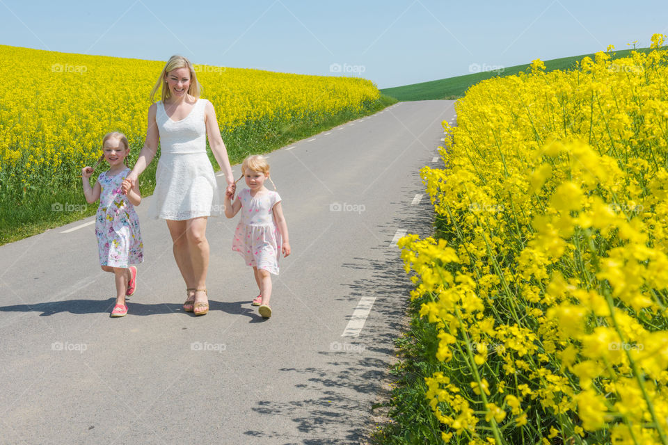 Woman walking with her two daughters on countryside road