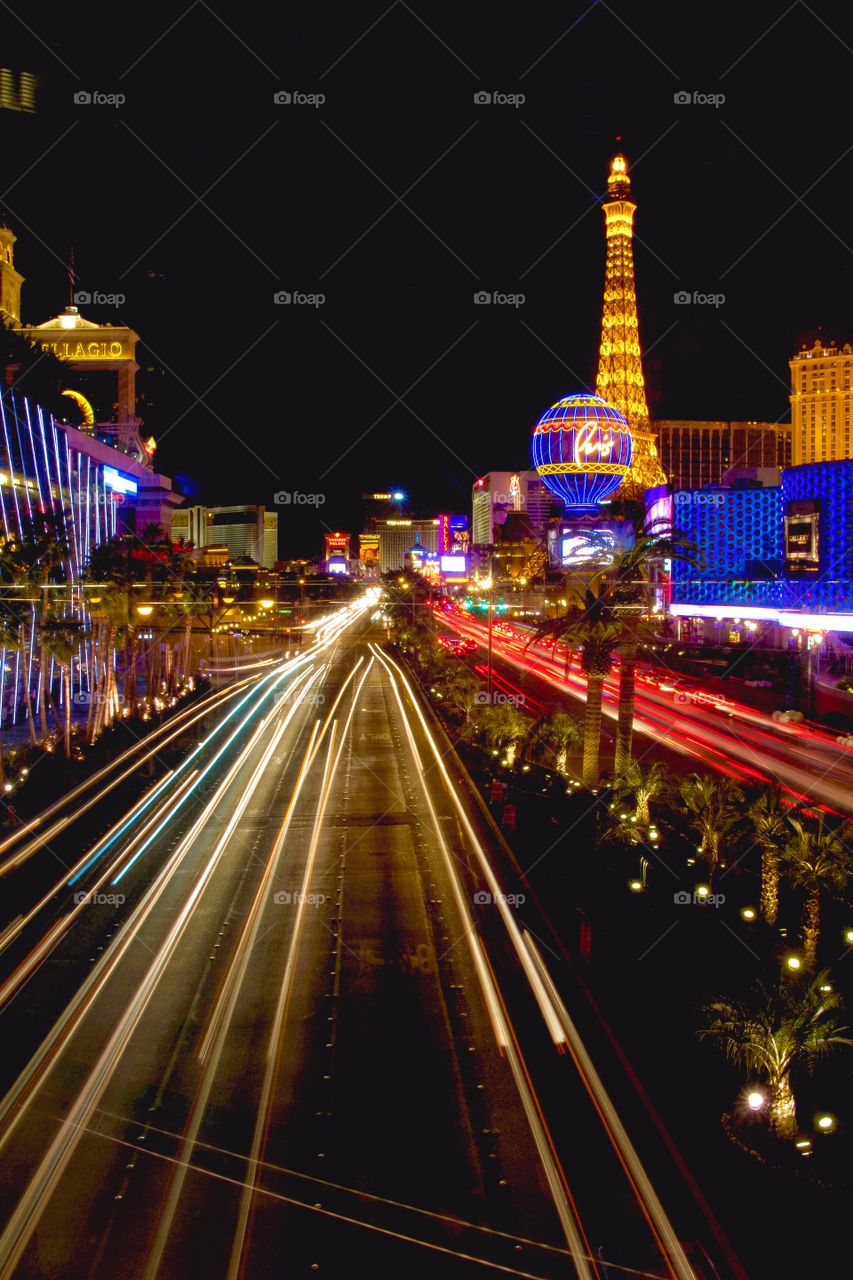 A long exposure of the the Las Vegas strip at night with headlight and tail lights going in opposite directions. 