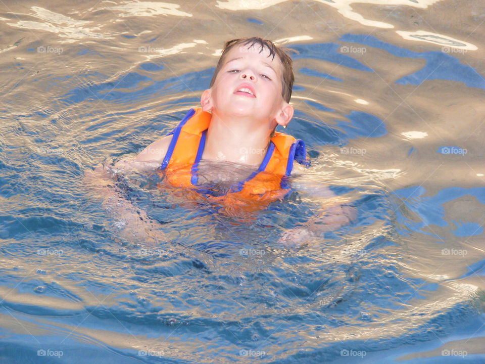 Good thing he is wearing a life vest because he is too tired to swim.