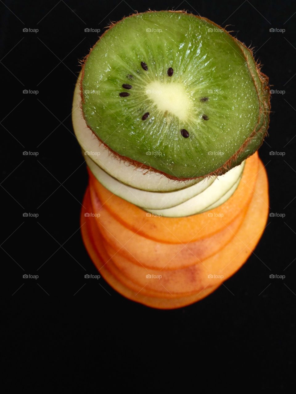 Fruits slices as a tower on black 