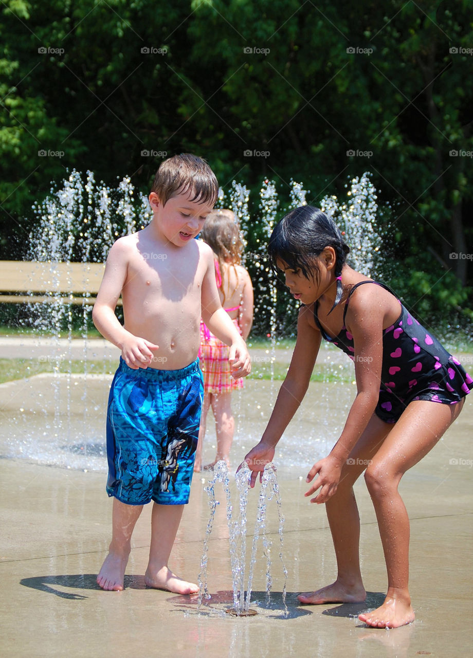 Kids having fun at a splash pad during summer vacation