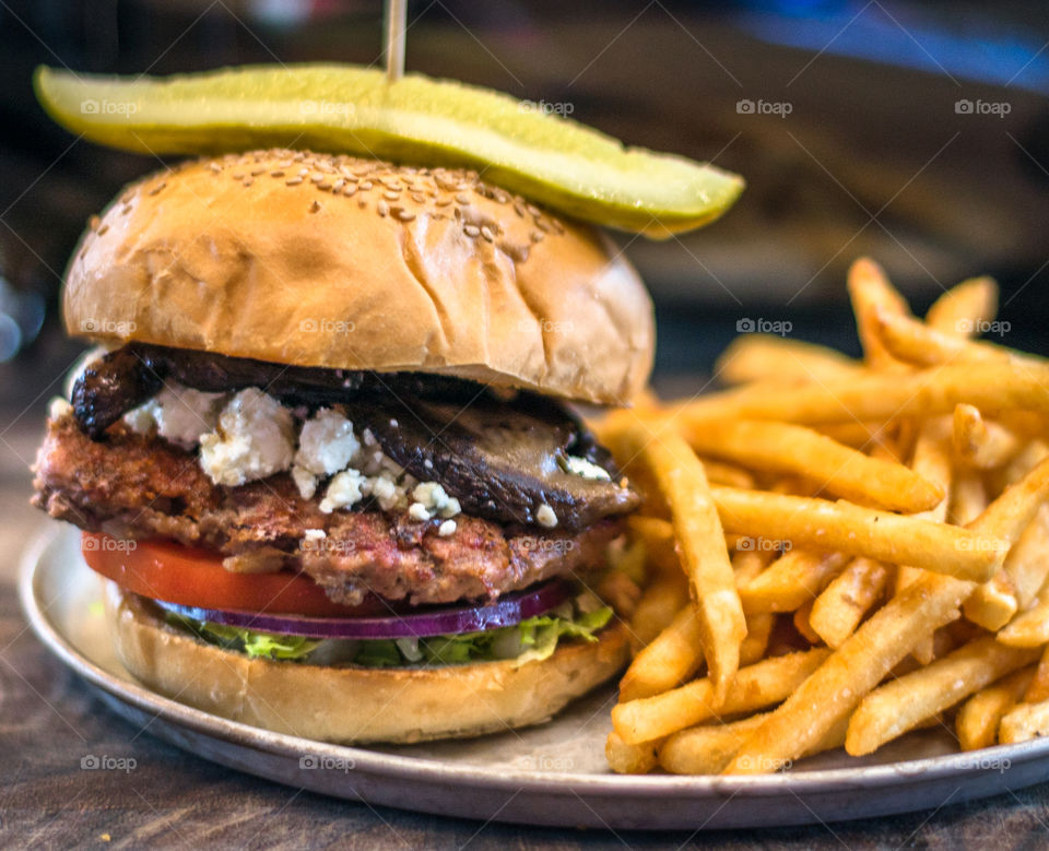 Big hamburger with blue cheese. Big hamburger with pickles and french fries