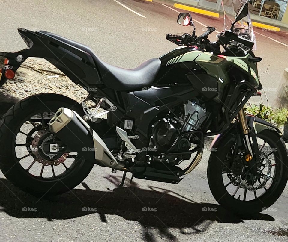 green and black Honda motorcycle parked outside an Oregon store at night in Summer