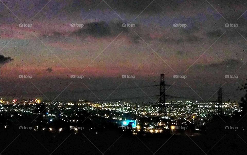 Light: natural vs artificial. looking the twilight and beautiful nightscape from a hill.