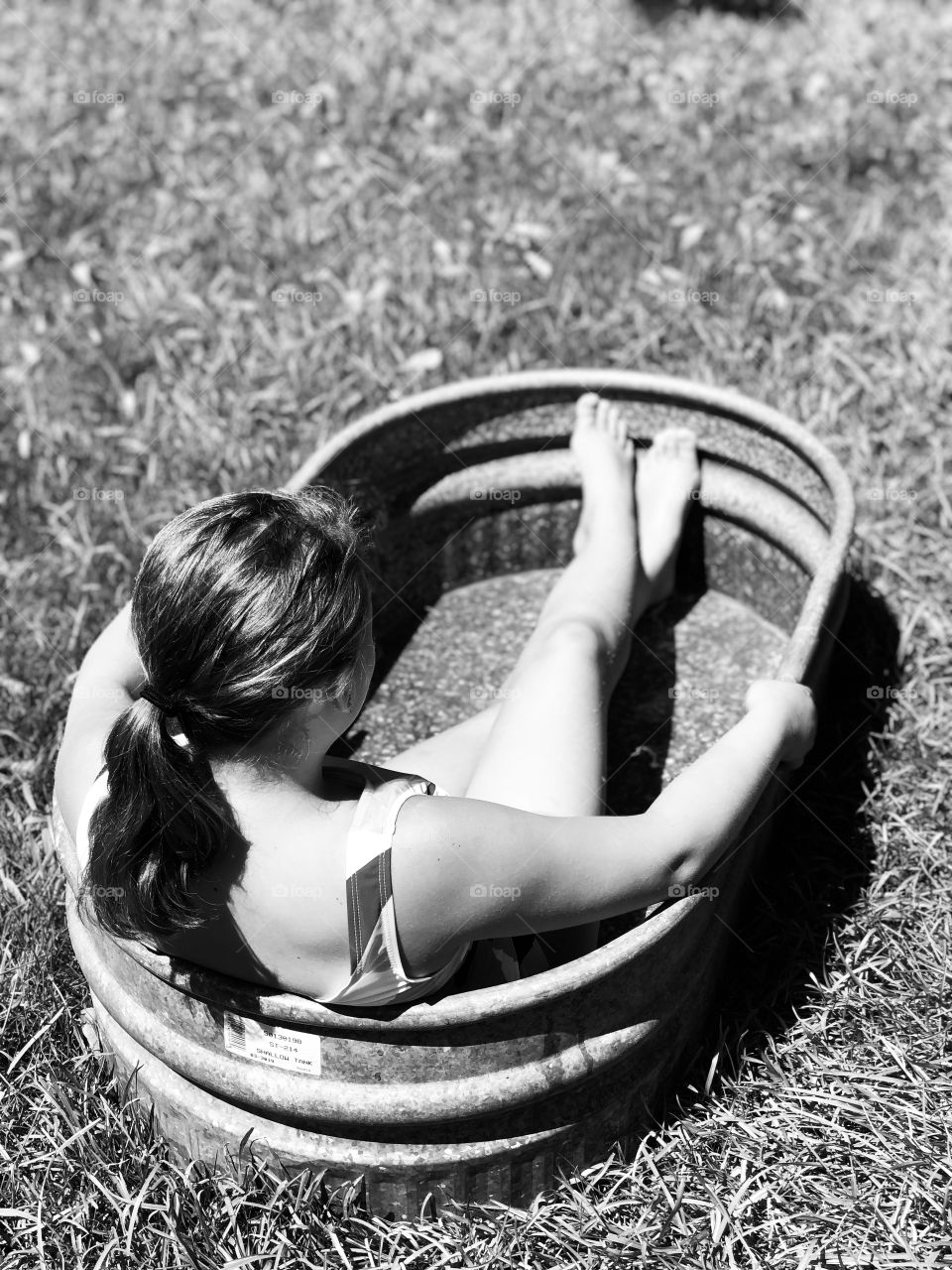 A girl sitting and sunbathing in trough. Black & White