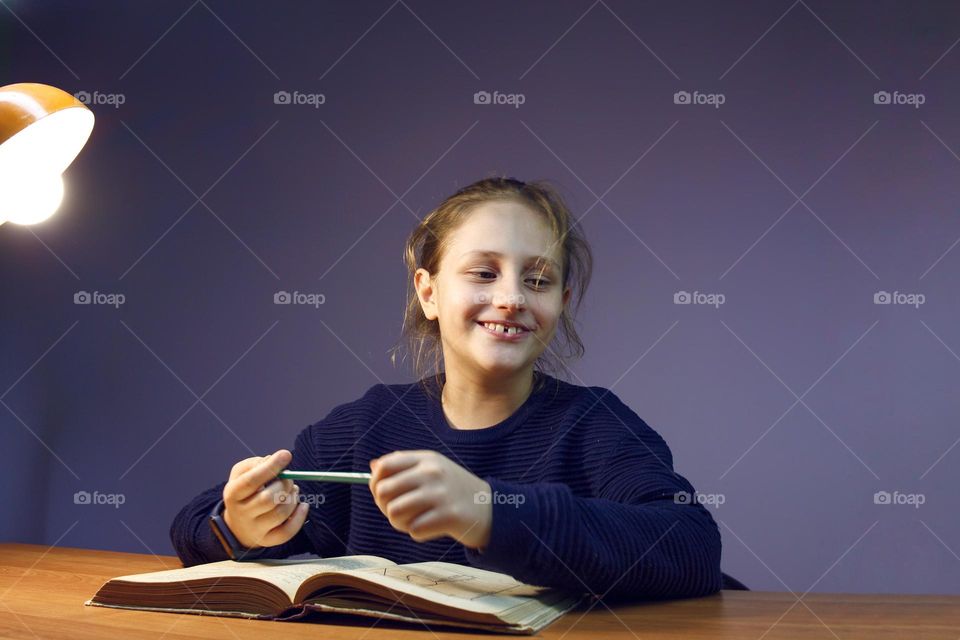 the girl laughs after finding a funny and incomprehensible moment in the book