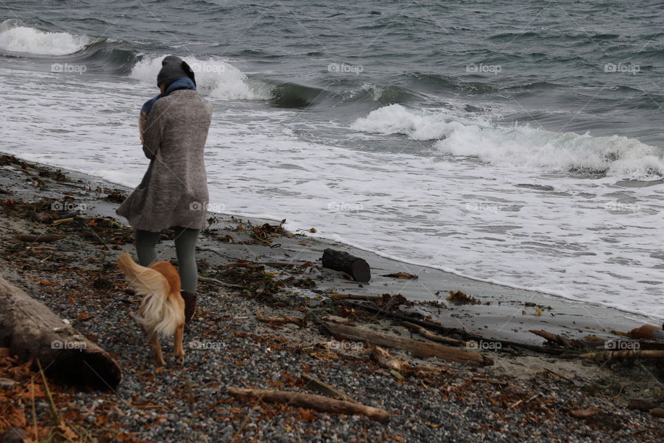 Woman wearing warm pullover waking the dog on a windy day