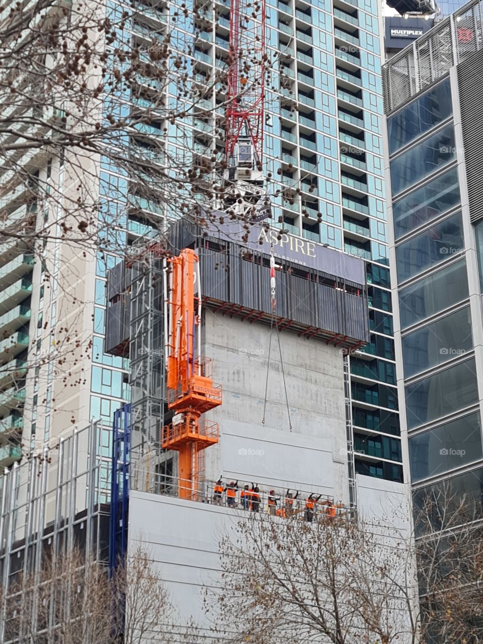 Workers placing building side walls on Melbourne Aspire Skyscraper