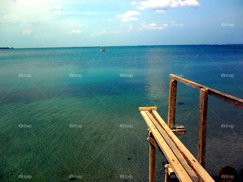 ocean and a wooden pier. ocean and a wooden pier in barcelona sorsogon in the bicol region of the philippines in asia