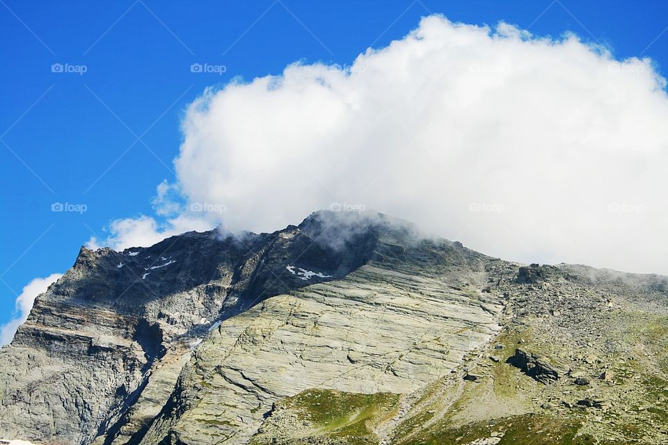 Clouds crashing a mountain on the Simplon pass in the Swiss / Italian Alps.