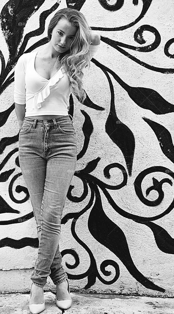 Woman standing in front of graffiti wall