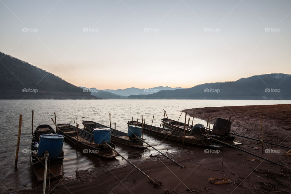 Boat docking in the river with sunrise 