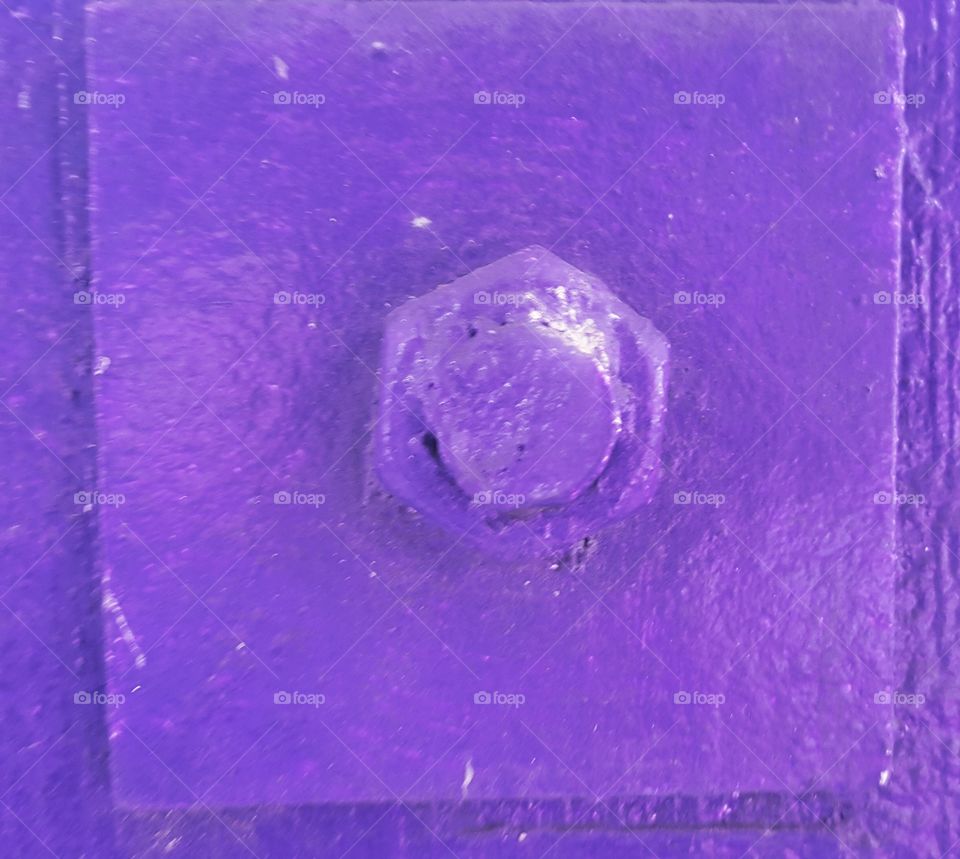Close-up of screw on purple wall