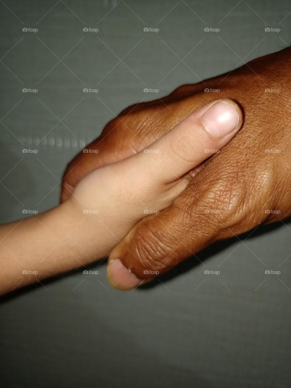 Young little boy shaking hands with old man Young and old combination clousup photo