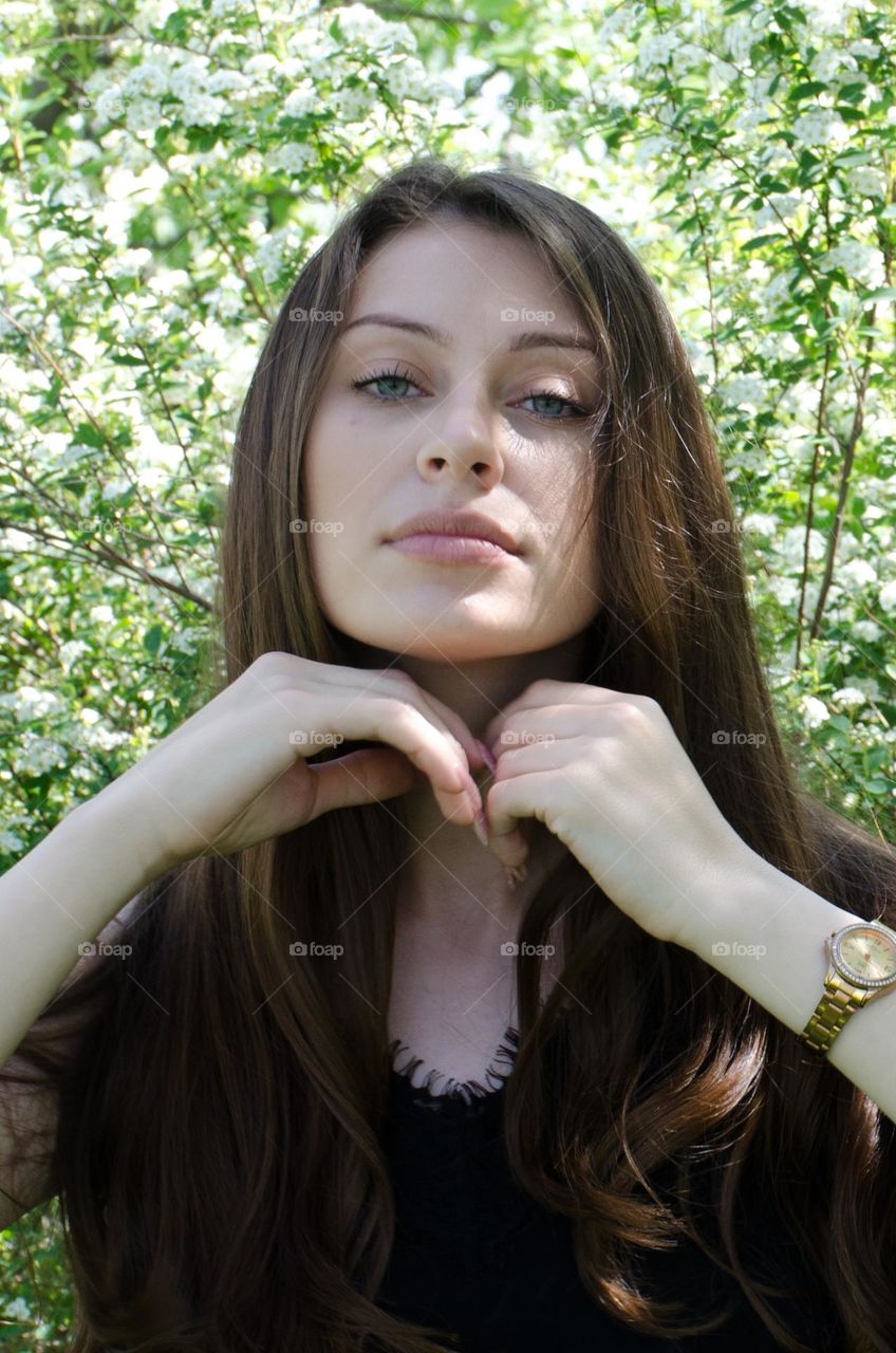 Beautiful Young Girl on Background of Flowers