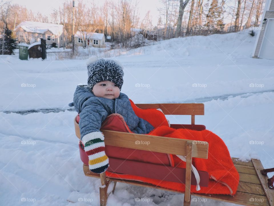 Cute boy sitting on wooden bench