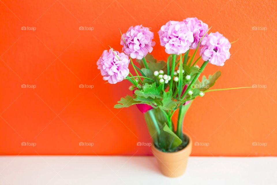 Cloth flowers on bright orange wall