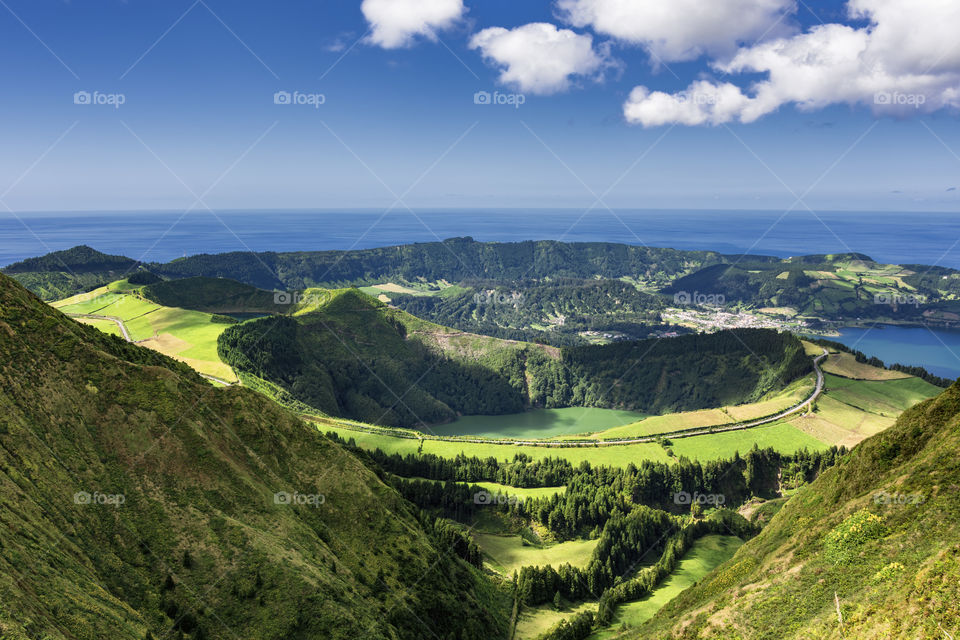 View from the trail to Sete Cidades in the island of Sao Miguel, Azores, Portugal. Meadows and vulcanic lake with ocean in the background.