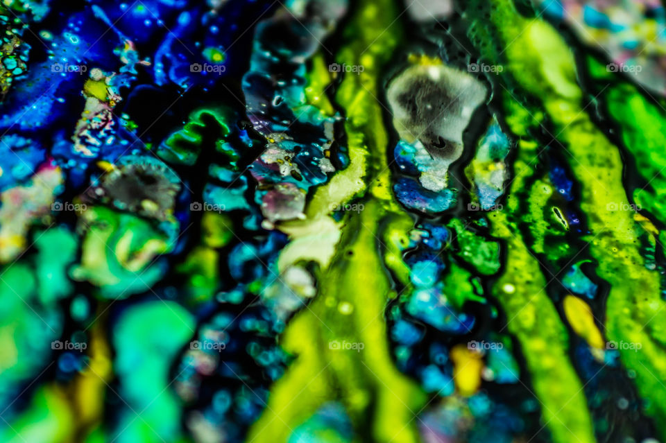 The ink to refill the printer cartridge was spilled onto the white washbasin and the paints blended into abstract drips and patterns