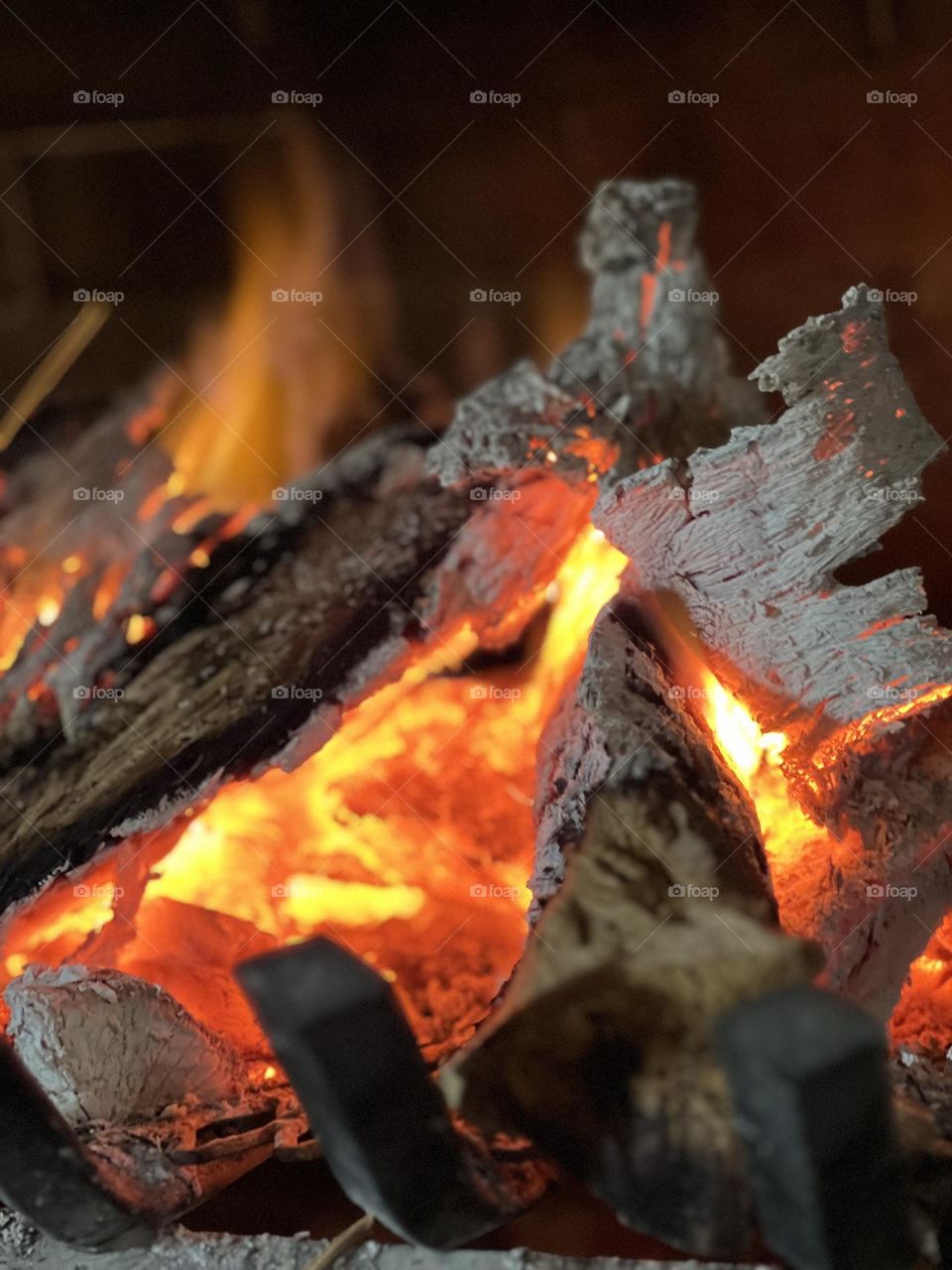 A much needed warm fire in the winter, burning red and yellow flames, peeling back the wood. 