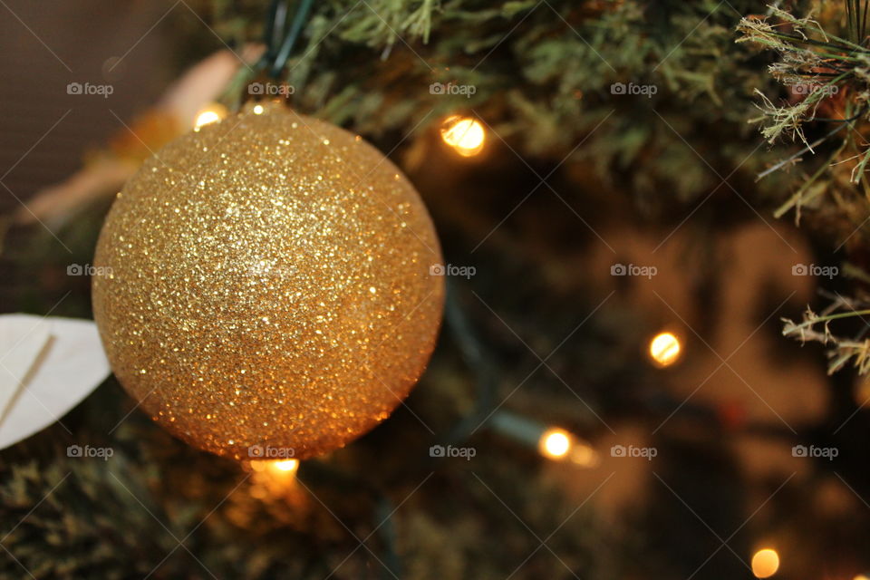Close-up of a golden ball in a Christmas tree 