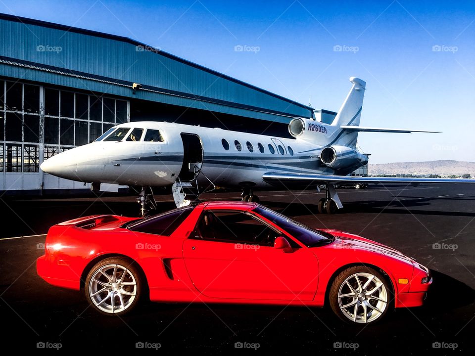 Acura NSX red sports car and business jet.  