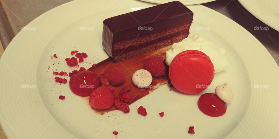 chocolate and raspberry terrine with chocolate sauce, whipped cream, raspberry meringue, raspberries, raspberry coulis, raspberry macaroon