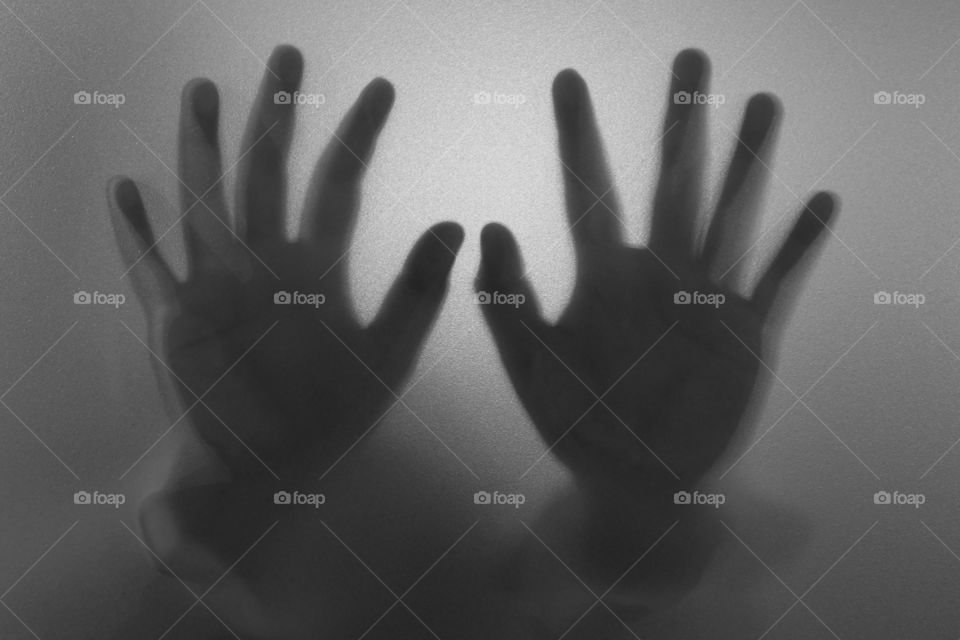 Terrifying hands behind a glass wall