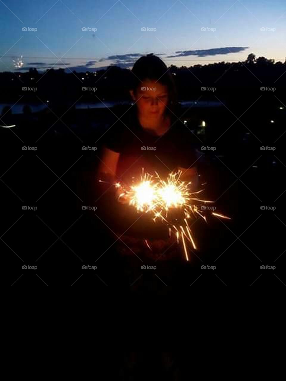 girl holding sparklers in the dark