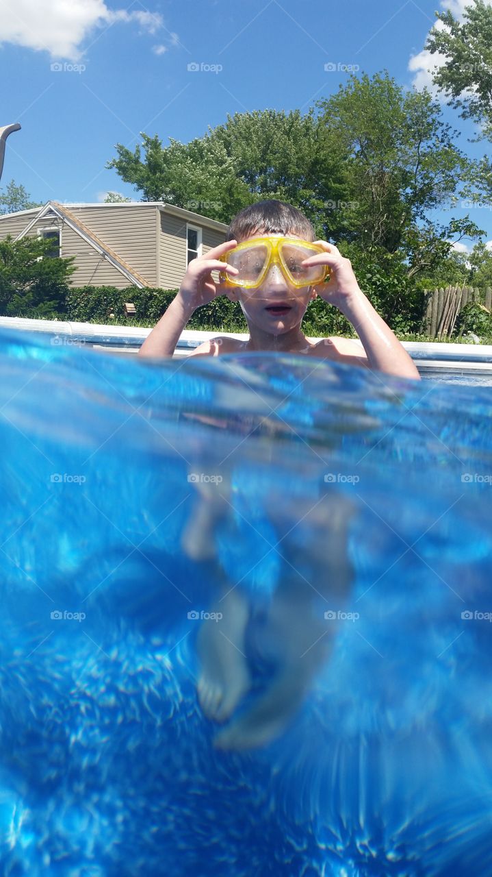 Small boy swimming in pool